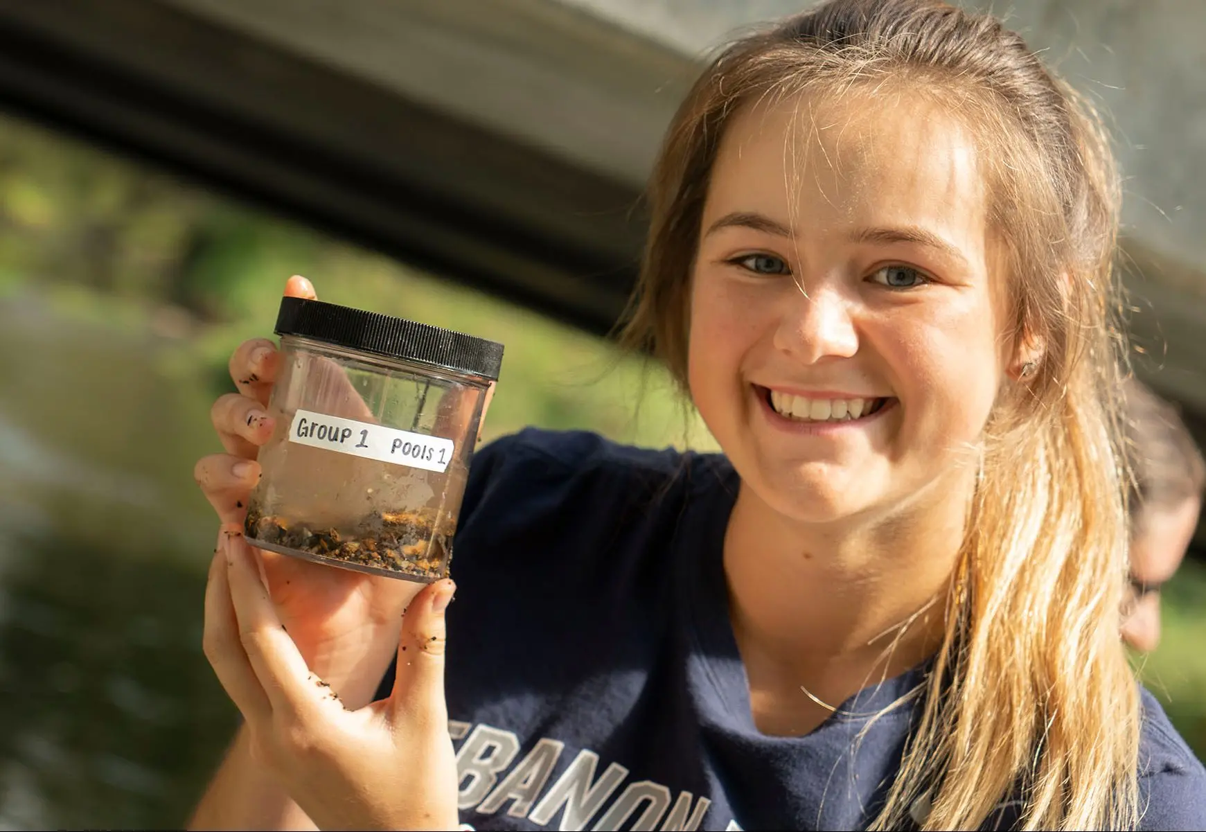 Student holding up labeled specimen jar