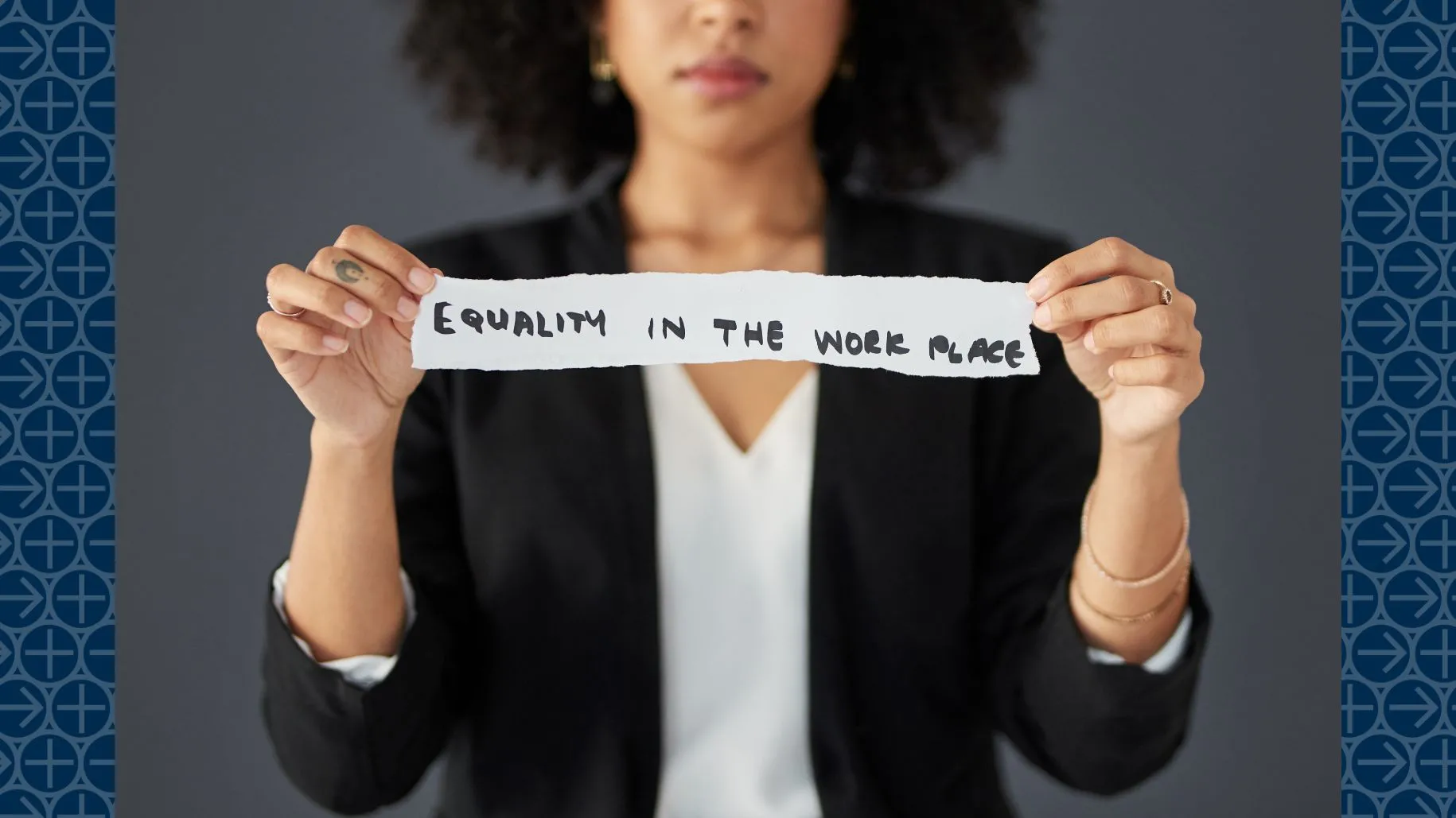 Woman holds paper that says "Equality in the workplace"